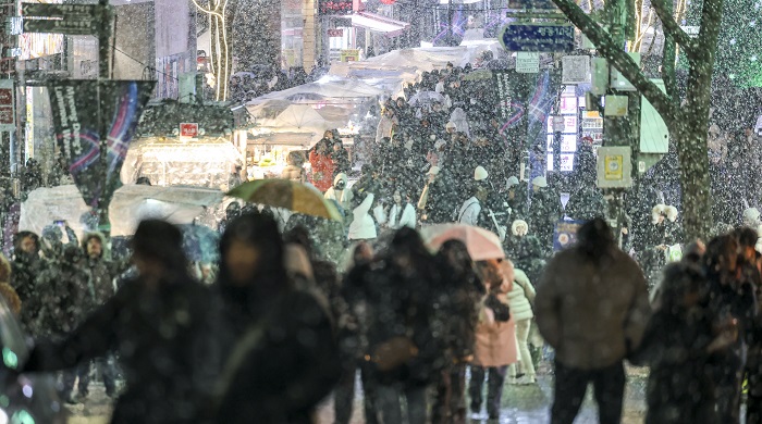 ▲겨울철 평균 기온 전망이 조정되고, 폭설이 몰려오는 것은 고온 현상 탓이다. (명동거리에 함박눈이 내리고 있다. 사진/뉴시스)