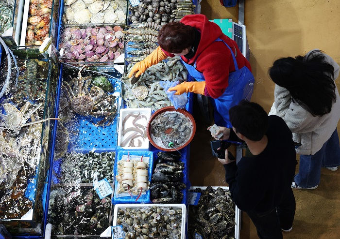 ▲설 연휴를 앞두고 온누리상품권 환급행사가 열린 지난 23일 충북 청주시 육거리종합시장의 행사 참여 점포에서 한 시민이 수산물을 구입하고 있다. (사진/뉴시스)